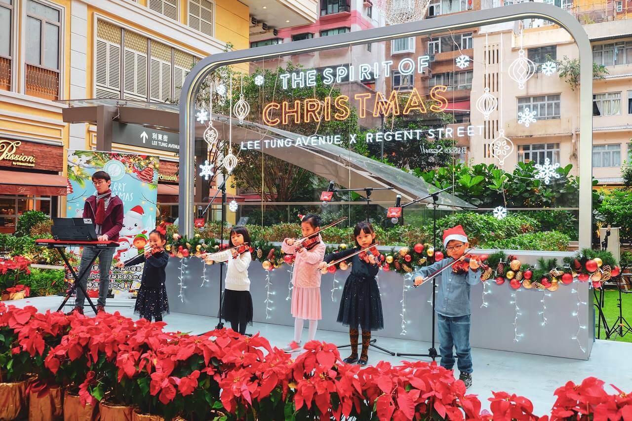 A group of boys and girls performing violin on stage at Lee Tung Ave, Hong Kong.