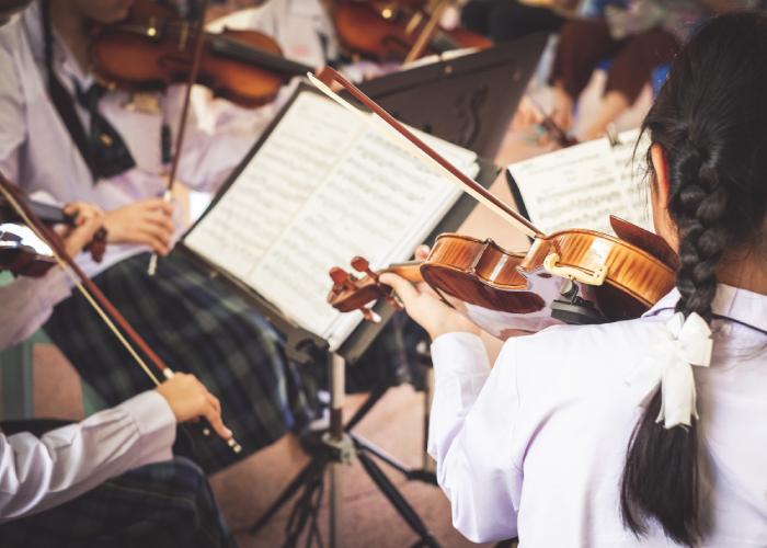 A close-up image of students practicing the violin.